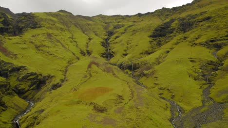 Línea-De-Cascadas-Que-Fluyen-Por-Un-Valle-Verde-Volcánico-En-El-Sur-De-Islandia