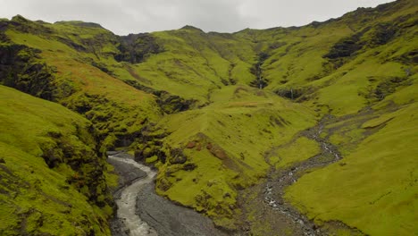 Río-Que-Fluye-En-Un-Valle-Volcánico-Verde-En-Las-Tierras-Altas-De-Islandia