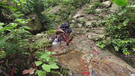 Woman-on-jungle-hike-uses-phone-to-film-low-angle-closeup-waterfall
