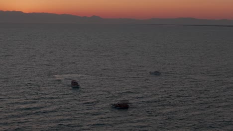 Eine-Gruppe-Kleiner-Boote,-Die-Gemeinsam-Auf-Dem-Glühenden-Mittelmeer-Bei-Sonnenuntergang-Vor-Der-Türkischen-Küste-Segeln