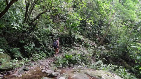 Mujer-Latina-Cruza-Un-Arroyo-En-Una-Caminata-Por-La-Selva-Tropical-En-Honduras
