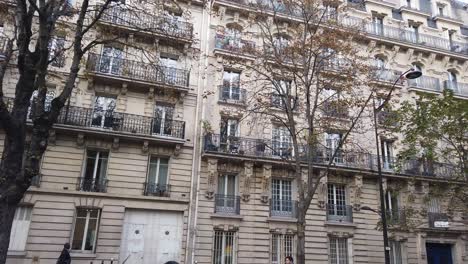 Fachada-De-Edificios-Antiguos-Con-Balcones,-Gente-Caminando-En-París,-Francia.