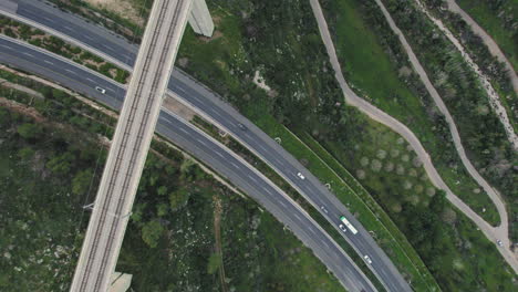 Statische-Aufnahme-Von-Oben-Nach-Unten-Auf-Eine-Riesige-Personenzugbrücke-Und-Darunter-Fahrende-Fahrzeuge-Am-Eingang-Von-Jerusalem,-Israel-–-über-Dem-Kidron-Tal-–-Der-Moderne-Zug-Kommt-Aus-Tel-Aviv