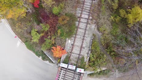 Drehende-Luftaufnahme-Einer-Alten-Eisenbahnbrücke-Während-Der-Herbstfarben