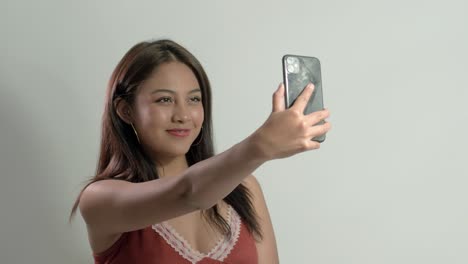 Latina-girl-joyfully-taking-a-selfie,-displaying-happiness-and-fun-while-capturing-special-moments-with-her-mobile-phone