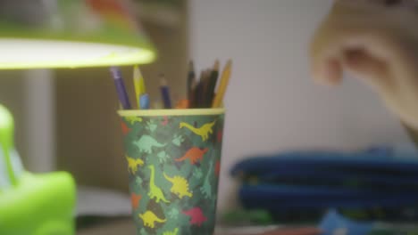 Kind-Zeichnet-Nachts-Auf-Seinem-Schreibtisch-Und-Malt-Mit-Farbigen-Farben