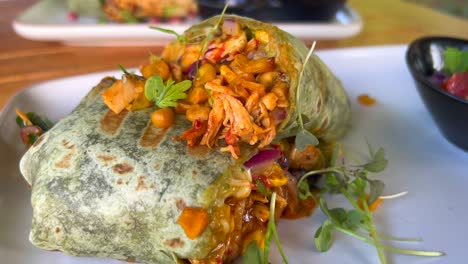 Delicious-healthy-chicken-wrap-with-vegetables-in-Marbella-Spain,-brunch-at-a-restaurant,-4K-shot