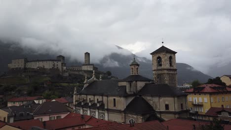 Cathedral-of-Bellinzona,-Swiss-Alps-Town-Landmark,-Castles-Panoramic-Foggy-Sky-in-Autumn,-Switzerland