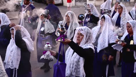 Peruvian-women-walking-backwards-with-incense-and-head-covered-by-a-veil-during-the-procession-of-lord-of-the-miracles