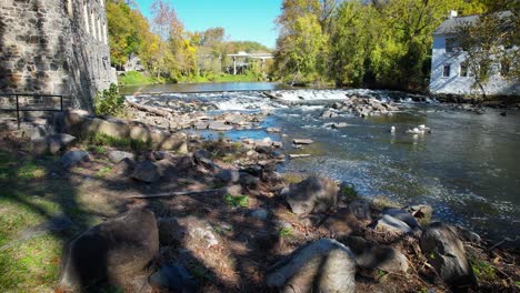 low-drone-flyover-stream-rapids-brandywine-river-in-autumn-in-delaware