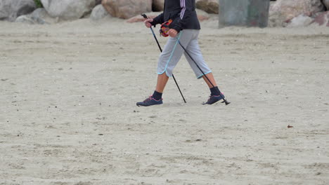 Cropped-Portrait-Of-Person-Walking-On-Sand-Dunes-With-Trekking-Poles