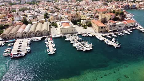 Calm-water-in-pier-with-yachts-and-Chania-in-background,-aerial-view