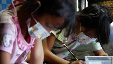 Asiatisches-Junges-Mädchen-Schreibt-Hausaufgabenheft,-Nahaufnahme