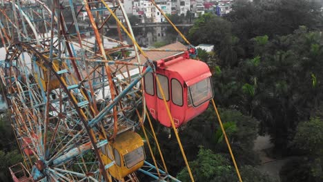 Aerial-view-of-the-abandoned-Hanoi-Ferris-wheel-under-the-radiant-daylight,-an-intriguing-sight-of-a-forgotten-amusement-towering-over-the-city