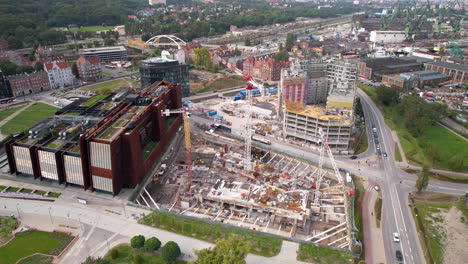 Aerial-view-of-Gdansk's-center-with-construction-activities-near-the-Solidarity-Museum,-showcasing-modern-architecture-and-city-roads