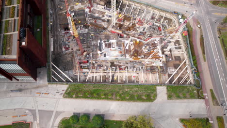 Aerial-view-of-a-bustling-construction-site-adjacent-to-a-serene-urban-park