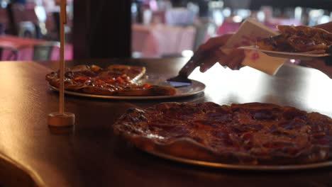 Person-Grabbing-a-Slice-of-Pizza-in-Slow-Motion