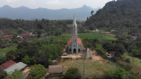 Flying-backwards-at-White-Catholic-Church-at-Tuyên-Quang-Vietnam,-aerial