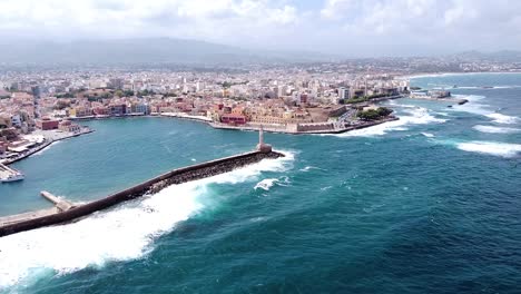 Powerful-waves-hitting-Chania-city-coast,-aerial-drone-view