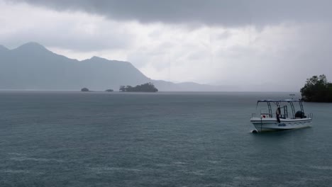 Moored-dive-boat-during-stormy-grey,-cloudy-and-wet-rainy-day-during-monsoon-season-in-Coron-Bay-of-Palawan,-Philippines