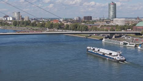 Aerial-of-a-cargo-ship-passing-beneath-a-bridge-on-the-Rhine-River
