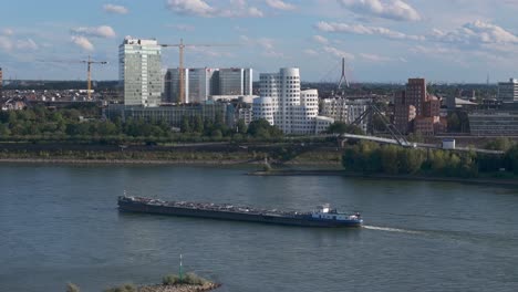 A-massive-cargo-vessel-glides-along-the-Rhine-River-in-Düsseldorf