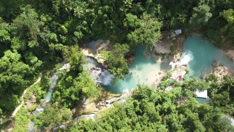Badian-Canyoning-Touristen-Auf-Dem-üppigen-Dschungelpfad-Zu-Den-Kawasan-Wasserfällen,-Um-In-Der-Vielschichtigen-Wasserfalllagune-Zu-Schwimmen