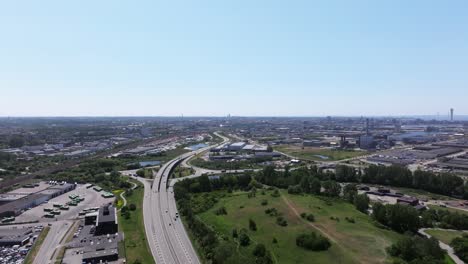 Aerial-forward-over-freeway-leading-to-Malmö,-Sweden-on-a-sunny-summer-day