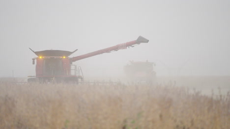 Combine-Harvester-with-Blinking-Lights-Harvesting-a-Dusty-Field-on-an-Overcast-Day