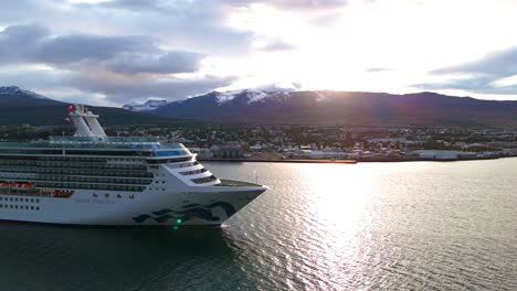 Aerial-view-of-huge-cruise-ship-navigating-along-the-atlantic-coastline-with-the-scenic-landscape-of-Iceland-in-the-background