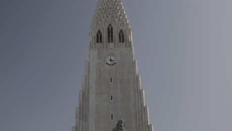 Panning-shot:-The-church-of-Hallgrimskirkja,-clock-tower-and-the-viking-monument-in-Iceland