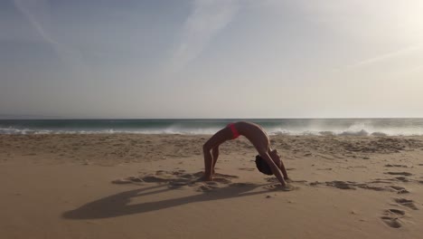 Young-Gymnast-Girl-Doing-Handstand-Bridge-At-The-Beach-In-Cadiz,-Spain