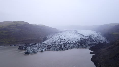 Sólheimajökull-Gletscherzunge-Aus-Eis-Und-Asche,-Die-In-Eine-Lagune-In-Island-Fließt