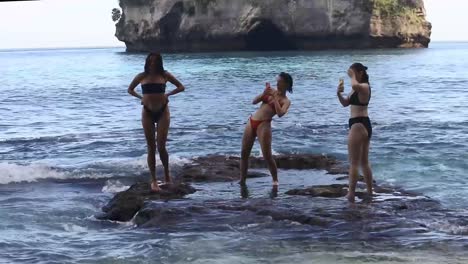 Shot-of-female-tourists-taking-selfies-on-the-edge-of-Diamond-Beach-in-Nusa-Penida,-Bali