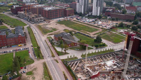 Aerial-view-of-urban-construction-site,-roads,-and-nearby-buildings---Gdansk,-Poland