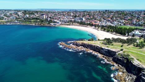 Drone-aerial-shot-of-Coogee-Bay-Beach-beachside-headland-coastline-cliff-housing-infrastructure-Randwick-Bondi-Maroubra-Eastern-Suburbs-travel-tourism-Sydney-NSW-Australia-4K