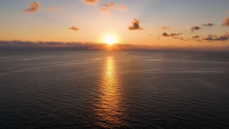 Erstaunlicher-Orangefarbener-Sonnenaufgang-über-Ruhigem-Meer,-Gefilmt-Von-Einer-Drohne