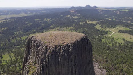 A-drone-shot-of-Devils-Tower,-a-massive,-monolithic,-volcanic-stout-tower,-or-butte,-located-in-the-Black-Hills-region-of-Wyoming