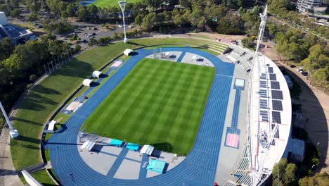 Drone-aerial-view-over-sports-fitness-training-facility-athletics-exercise-oval-track-running-health-competition-show-ground-Sydney-Olympic-Park-Homebush-Bay-NSW-Australia-tourism-4K