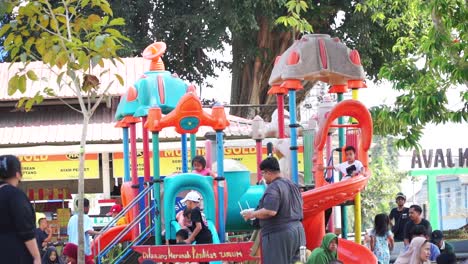 The-playground-is-crowded-with-children.-Children's-slide