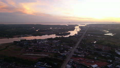 Luftaufnahme-Bei-Sonnenuntergang-Von-Surat-Thani-Ist-Eine-Stadt-In-Amphoe-Mueang-Mit-Fluss-Und-Fähre-Für-Inselhüpfen,-Touristisches-Urlaubsziel-In-Thailand,-Südostasien