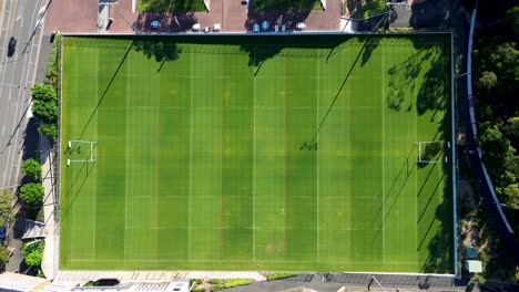 Drone-aerial-bird's-eye-view-of-football-NRL-rugby-oval-field-training-facility-goal-post-grass-park-sports-fitness-arena-road-street-Sydney-Olympic-Park-Homebush-Bay-NSW-Australia-4K