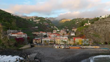 Waves-roll-onto-shore-by-the-small-town-of-Ponto-do-Sol,-Madeira