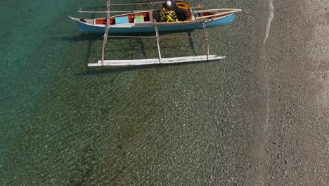 Aerial-slowmo-flyby-above-a-fisherman's-outrigger-boat-on-the-shore