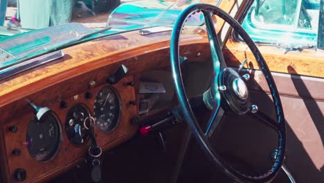 Steering-wheel-and-dashboard-of-a-vintage-car-exhibited-during-a-classic-car-meeting-in-Bozen---Bolzano,-Italy
