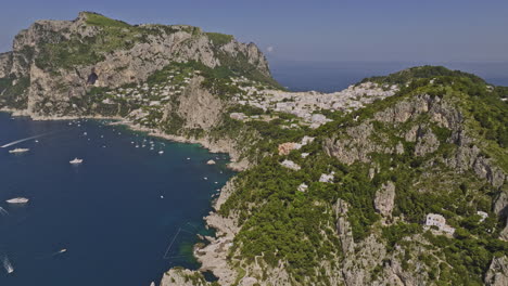 Capri-Italy-Aerial-v7-cinematic-drone-fly-along-the-sea-capturing-idyllic-charm-of-coastal-beauty,-rugged-cliffside-neighborhoods-and-quaint-island-town-in-summer---Shot-with-Mavic-3-Cine---May-2023