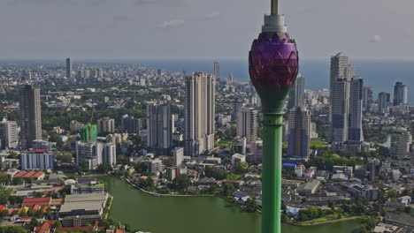 Colombo-Sri-Lanka-Aerial-v7-cinematic-flyover-area-10-capturing-Beira-lake-and-symbolic-landmark-Lotus-tower,-downtown-cityscape-with-Indian-ocean-in-the-backdrop---Shot-with-Mavic-3-Cine---April-2023