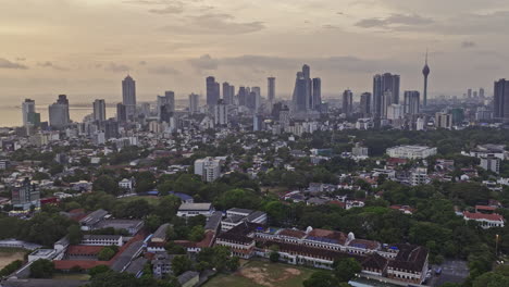 Colombo-Sri-Lanka-Aerial-v29-flyover-Cinnamon-Gardens-and-Kurunduwatta-capturing-college-campus,-upscale-homes-and-downtown-cityscape-on-the-skyline-at-sunset---Shot-with-Mavic-3-Cine---April-2023