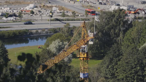 Yellow-hoisting-crane-at-construction-site,-moving-and-swinging