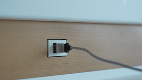 Plugging-in-iPhone-Charger-to-USB-Outlet